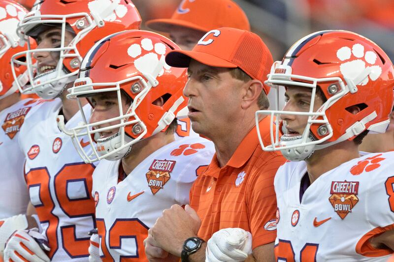Clemson coach Dabo Swinney, second from right, walks with players before the Cheez-It Bowl against Iowa State, Dec. 29, 2021.