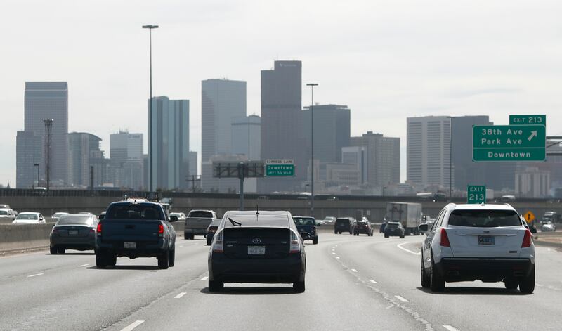 Pollution shrouds the skyline of downtown Denver as traffic moves southbound along Interstate 25 in Denver.