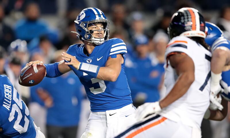 BYU Cougars quarterback Jaren Hall, wearing blue, sets for a pass