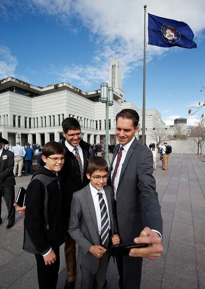 Steve Spigarelli, right, his son, Henry, his brother, David, and David's son, Daniel, take a photo before the 189th Annual General Conference of The Church of Jesus Christ of Latter-day Saints outside the Conference Center in Salt Lake City on Saturday, A