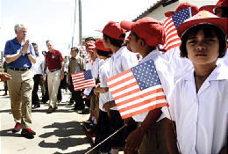 Former U.S. presidents Bill Clinton, left, and George H.W. Bush, white slacks, greet children in southern Thailand who were orphaned by the Dec. 26 tsunami. The pair are raising funds to help in reconstruction.