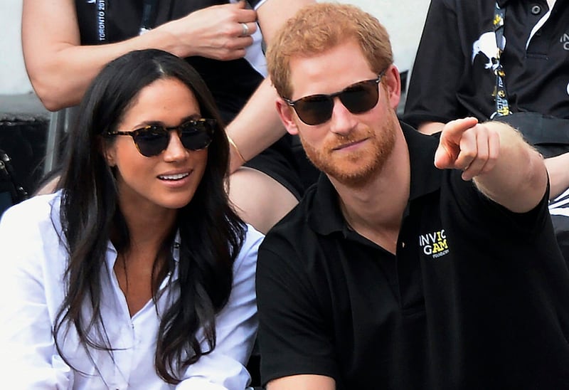 FILE - In this Monday, Sept. 25, 2017 file photo, Britain’s Prince Harry and his girlfriend Meghan Markle attend the wheelchair tennis competition during the Invictus Games in Toronto. Palace officials announced Monday Nov. 27, 2017, Prince Harry and Megh