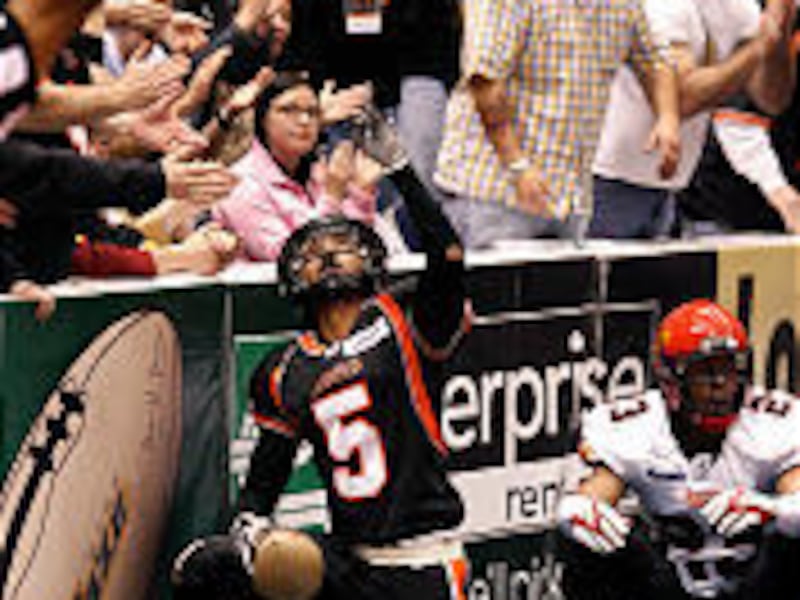 The Blaze's Siaha Burley, left, celebrates after scoring a touchdown Saturday over the Dragons' Dahnel Singfield at the Delta Center.