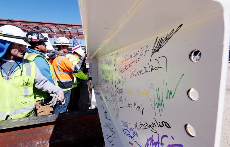 Workers sign the final beam to be placed on the north concourse at the Salt Lake City International Airport is pictured with an American flag during a topping-off ceremony on Tuesday, March 19, 2019. The airport is currently undergoing a $3.6 billion airp