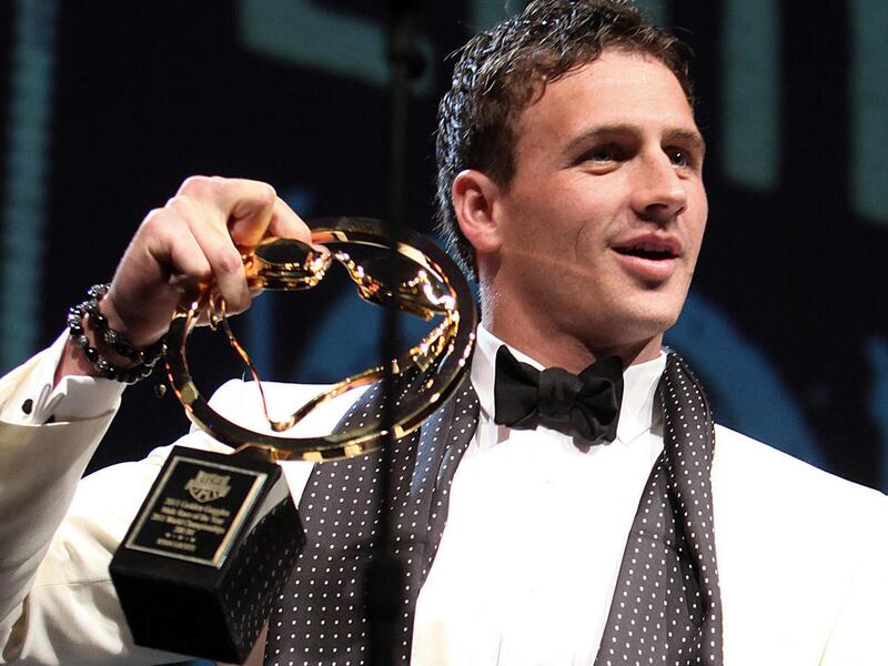 After knocking the award off the podium and grabbing it before it hit the floor, Ryan Lochte holds the award for best male race of the year at the USA Swimming Foundation's Golden Goggle awards in Los Angeles Sunday, Nov. 20, 2011.
