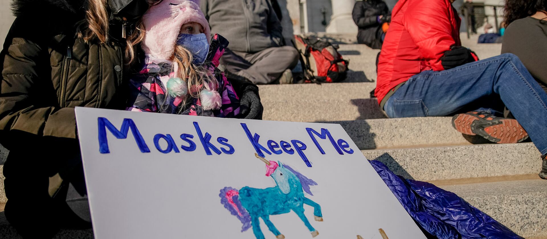 Christine Maugham holds her daughter, Imogen Cracroft, 9, during the Concerned Coalition Public Health Rally at Utah State Capitol in Salt Lake City.
