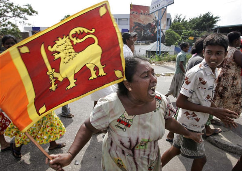 A woman holds the Sri Lankan flag as she celebrates the military's victory over rebels Monday in Colombo.