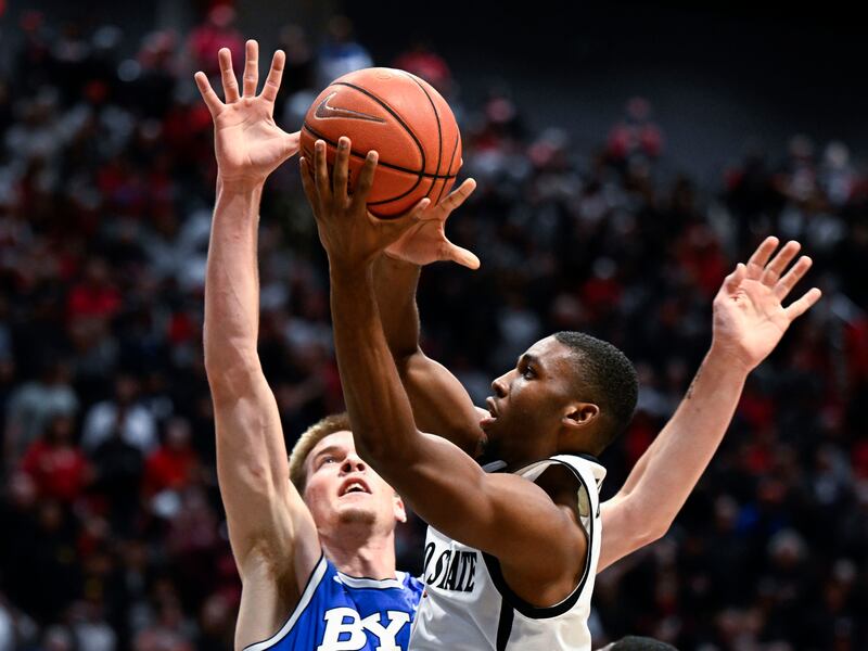 San Diego State guard Lamont Butler, right, shoots past BYU forward Noah Waterman during the second half of an NCAA college basketball game Friday, Nov. 11, 2022, in San Diego. (AP Photo/Denis Poroy)