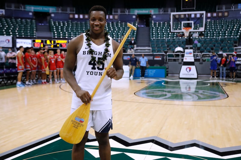 BYU forward Fousseyni Traore holds an All-Tournament Team trophy, a paddle