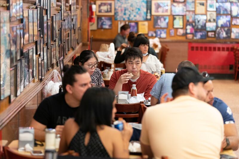 In this Sept. 30, 2020 file photo, customers have lunch at Katz’s Delicatessen in New York. New York Mayor Bill de Blasio said Thursday, Nov. 19, 2020, that indoor restaurant service will likely shut down within a week or two to curb the spread of the coronavirus.
