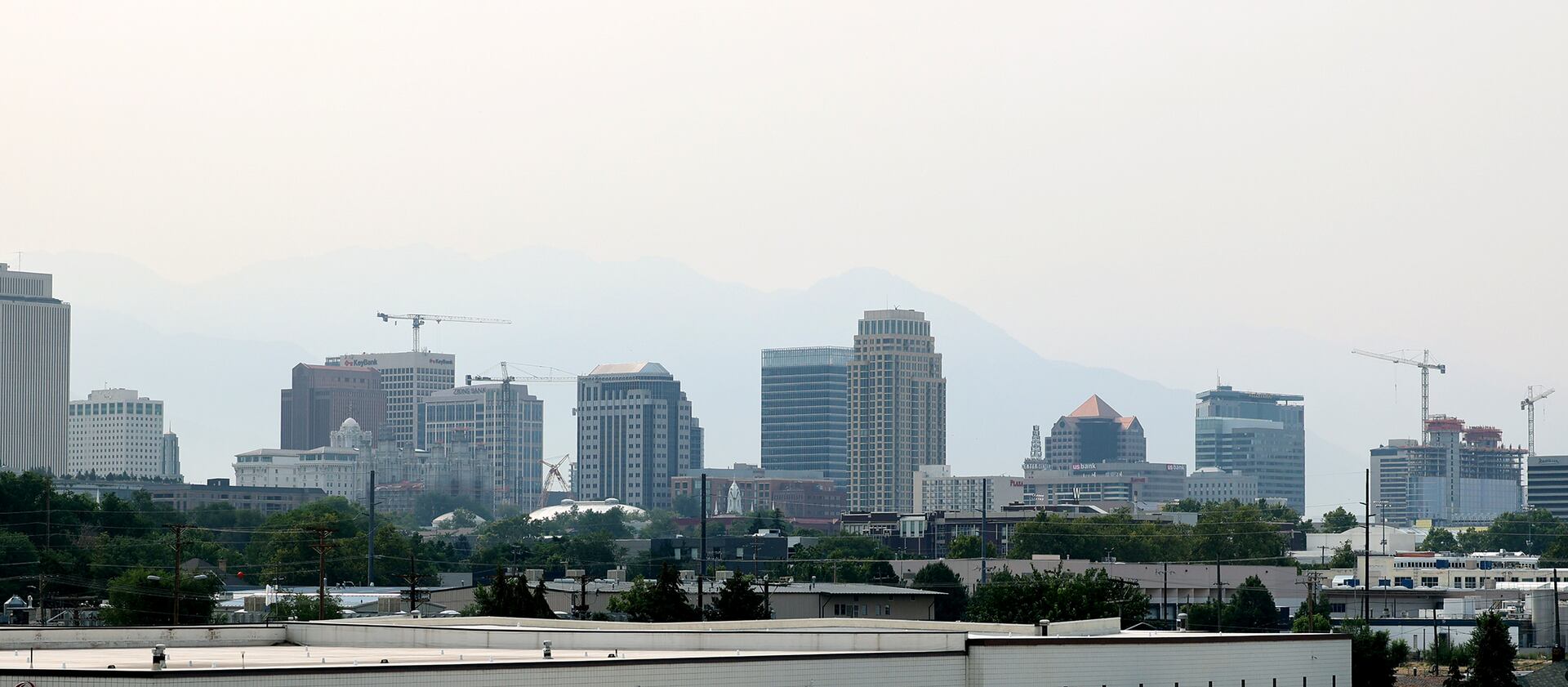 Smoke obscures the mountains behind the Salt Lake City skyline.