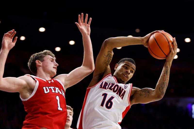 Arizona forward Keshad Johnson (16) controls a defensive rebound over Utah forward Ben Carlson during the first half of an NCAA college basketball game Saturday, Jan. 6, 2024, in Tucson, Ariz. (AP Photo/Chris Coduto)