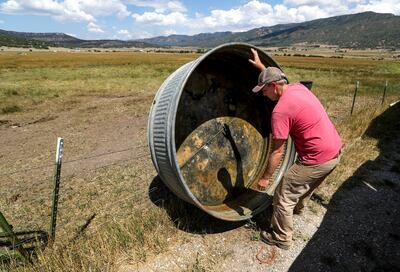 Jay Hansen readies a water trough, intended for his cattle, in Milburn, Sanpete County, on Friday, Aug. 17, 2018. Hansen and his brother, Dave, have been bringing their cattle off nearby mountains because the Coal Hollow Fire is threatening their grazing