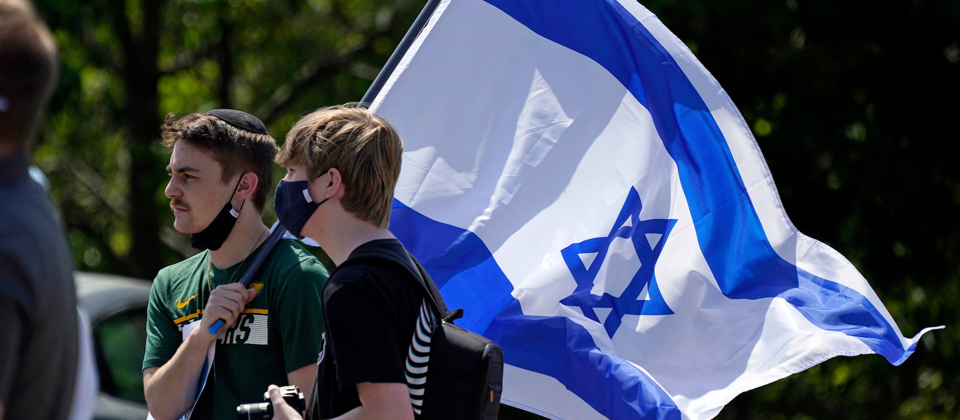 Two young men carry an Israeli flag at a peace vigil in support of Israel in Philadelphia in May 2021.