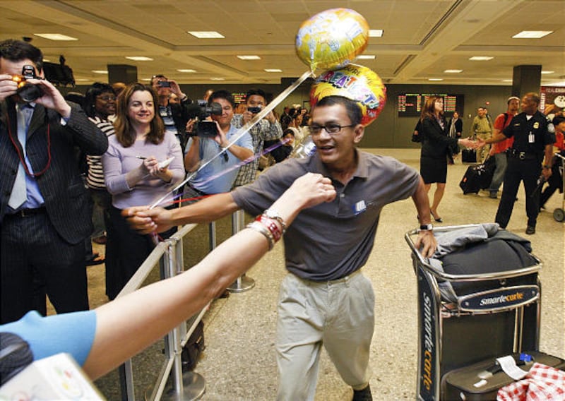 Nyi Nyi Aung, a pro-democracy activist originally from Myanmar who was freed Thursday, reaches to hug fiancee Wa Wa Kyaw at Dulles.