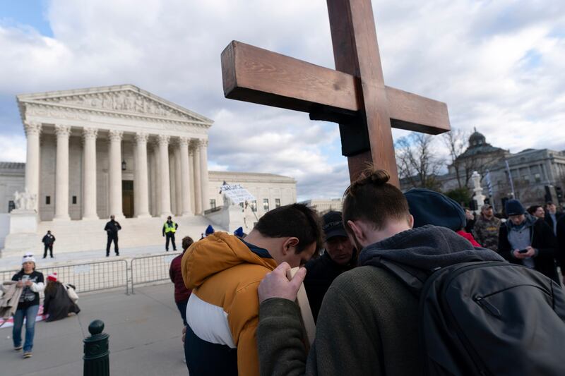 Anti-abortion activists have a prayer under a cross as they rally outside of the U.S. Supreme Court during the March for Life.