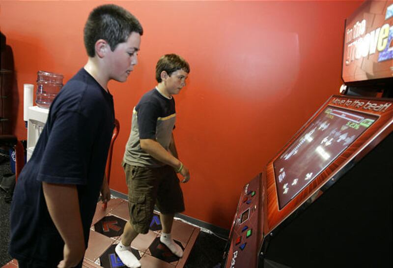 Alex Longanecker, 13, left, and Alex Lenail, 13, work out on a dancing game at Overtime Fitness in Mountain View, Calif.