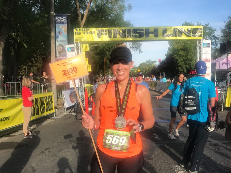 Meridith Ethington holds her pace setter placard for Deseret News 10K race.