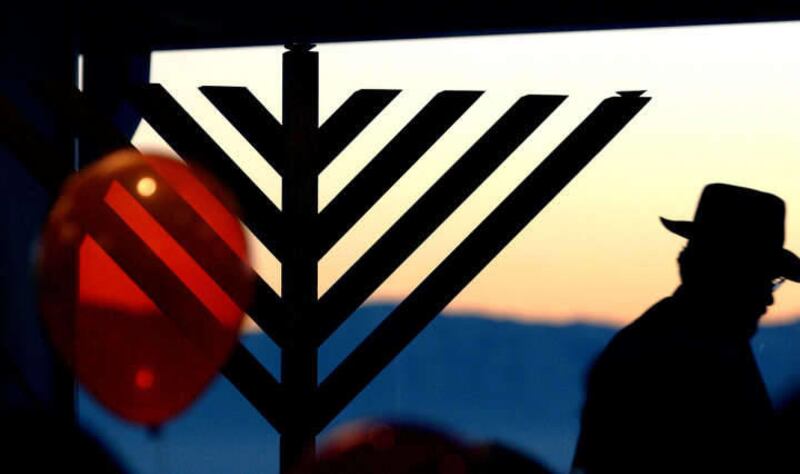 A menorah is lit with one candle in this 2009 file photo. Lawyers for Travis Air Force Base determined that a Nativity scene and a menorah do not violate troops\' religious freedom.