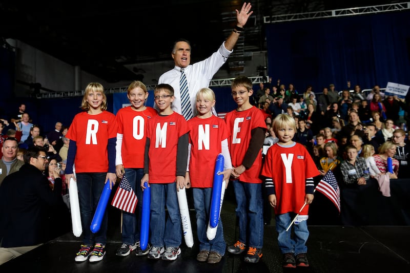 Then-Republican presidential candidate and former Massachusetts Gov. Mitt Romney poses with children wearing shirts which spell out “Romney” as he campaigns at the Iowa Events Center, in Des Moines, Sunday, Nov. 4, 2012.