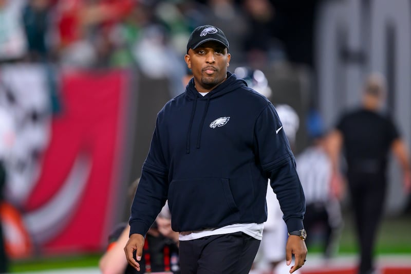 Philadelphia Eagles offensive coordinator Brian Johnson stands on the field before an NFL wild-card playoff game.