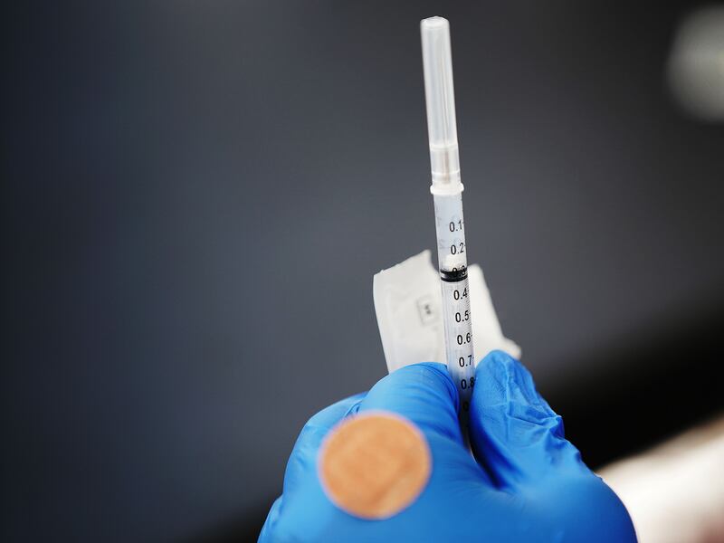 A healthcare worker holds a COVID-19 vaccine.