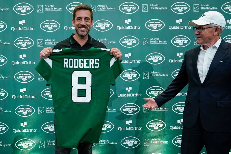 New York Jets quarterback Aaron Rodgers, left, poses for a picture while Jets’ owner Woody Johnson gestures after a news conference.
