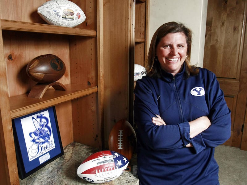 Holly Mendenhall wife of BYU Head Football Coach Bronco Mendenhall poses Friday, May 11, 2012 in their home with some of the sports memorabilia. Mendenhall and her sons will make a bike trek to Boise for a good cause.