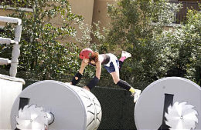 Contestant leaps between "logs" in Log Roll on "Extreme Elimination."
