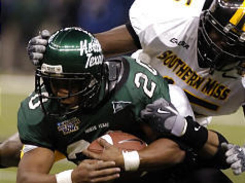 North Texas running back Jamario Thomas (20) is brought down by University of Southern Mississippi linebacker Kevis Coley.