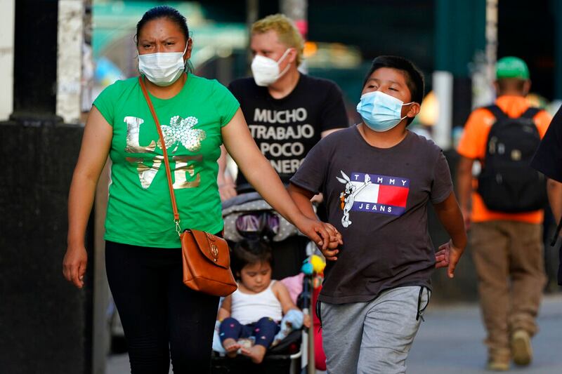 People wear protective masks during the coronavirus pandemic, in the Queens borough of New York.