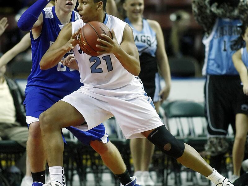 West Jordan's #21 Jordan Loveridge, center front, drives across the lane on Fremont's #24 Brock Smith, left back, as West Jordan and Fremont play Tuesday, Feb. 28, 2012 at the Maverik Center in the first round of state playoffs.
