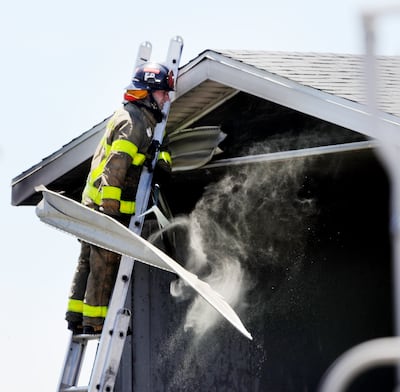 A fireman pulls siding out of the roof as Salt Lake and West Valley fire crews respond to a fire at RM Rubber Co. in Salt Lake City on Monday, July 22, 2019. A heat advisory for Monday and Tuesday has been issued as temperatures top 100 degrees.