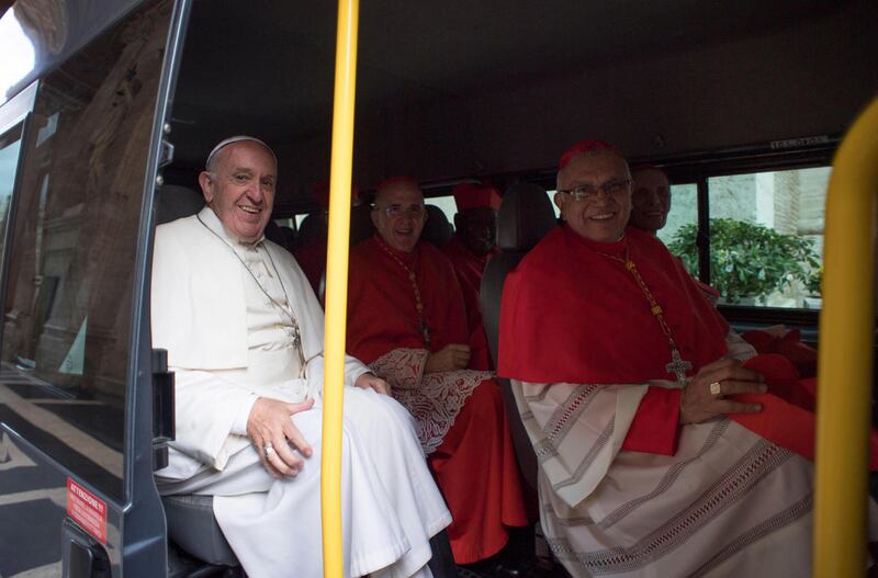 Pope Francis, left, and new cardinals sit on a mini-bus as they leave for the former Convent Mater Ecclesiae at the Vatican, Saturday, Nov. 19, 2016. After the basilica ceremony, the new cardinals and Pope Francis took two mini-buses to the monastery on V