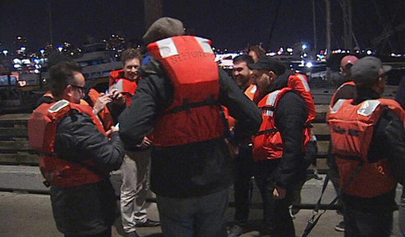 This image provided by KTVU-TV shows some of the 22 rescued passengers on the pier Friday Oct.12, 2012 in San Francisco. A U.S. Coast Guard spokesman said the wine-tasting boat, Neptune hit a shoal near Alcatraz Island and began sinking. Nearly two dozen