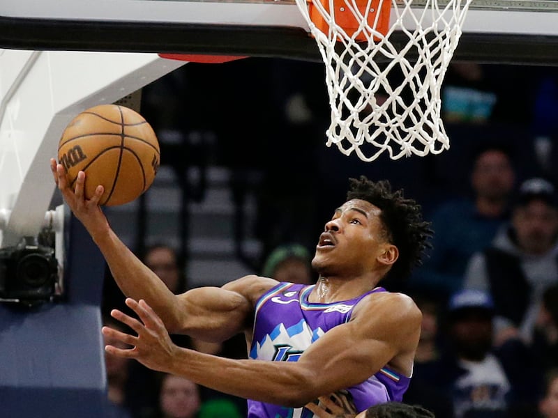 Utah Jazz guard Ochai Agbaji, wearing purple, shoots over Minnesota Timberwolves guard D’Angelo Russell (0) in the fourth quarter of an NBA basketball game Monday, Jan. 16, 2023, in Minneapolis.