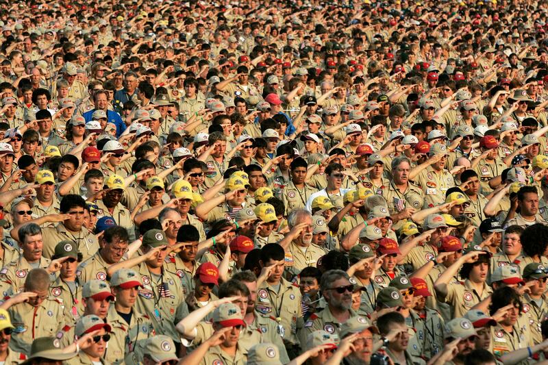 FILE - In this July 31, 2005 file photo, Boy Scouts salute as they recite the Pledge of Allegiance during the Boy Scout Jamboree in Bowling Green, Va. In 2019, financial threats to the Boy Scouts have intensified as multiple states consider adjusting thei