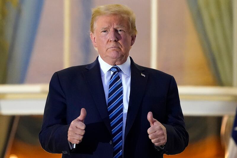 President Donald Trump stands on the balcony outside of the Blue Room as returns to the White House Monday, Oct. 5, 2020, in Washington, after leaving Walter Reed National Military Medical Center, in Bethesda, Md. Trump announced he tested positive for COVID-19 on Oct. 2.