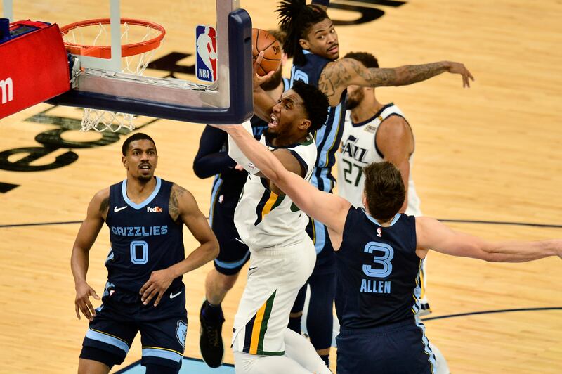 Utah Jazz guard Donovan Mitchell shoots between three Memphis Grizzlies defenders during Game 4 of their playoff series.