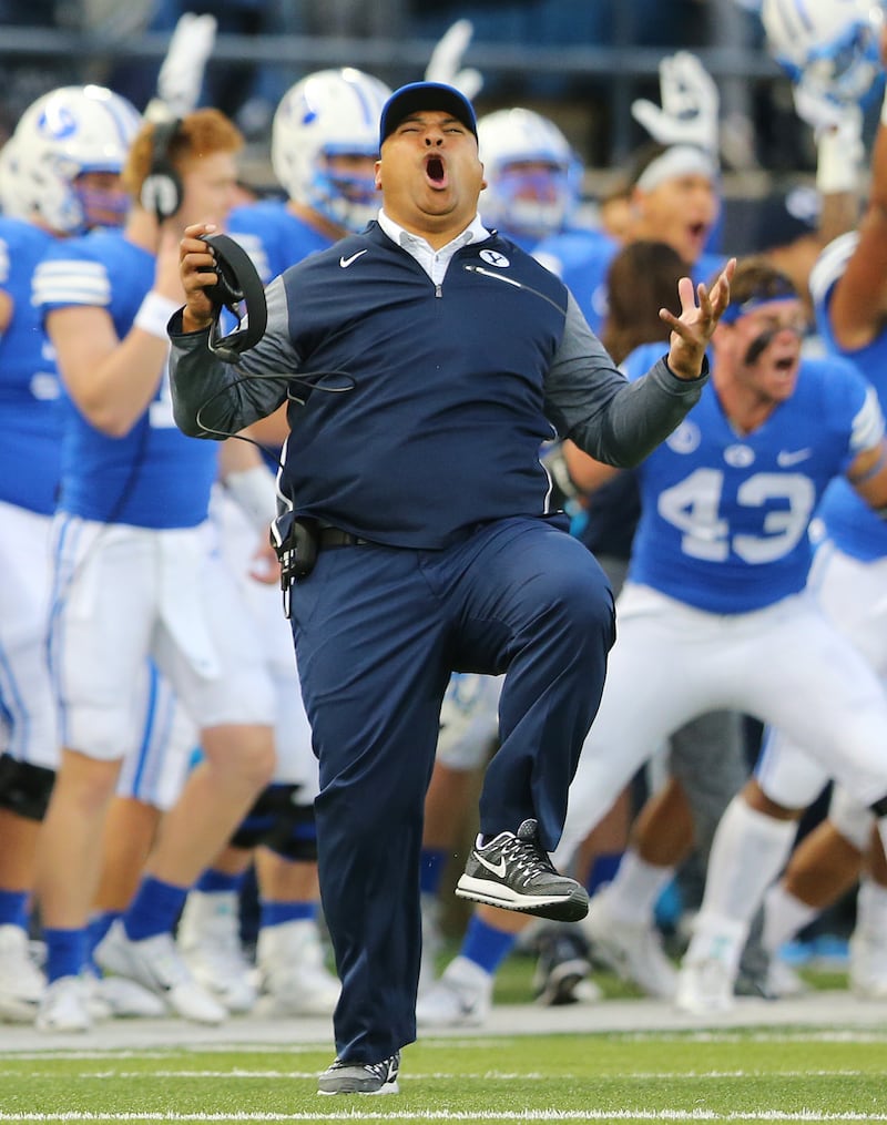BYU head coach Kalani Sitake celebrates a touchdown as BYU and Utah State play at Maverik Stadium in Logan on Sept. 29, 2017.