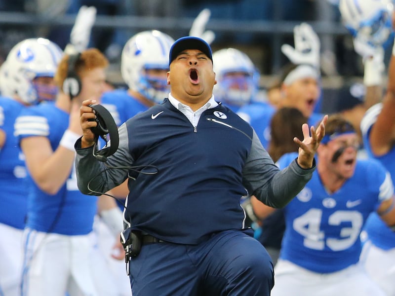 BYU head coach Kalani Sitake celebrates a touchdown as BYU and Utah State play at Maverik Stadium in Logan on Sept. 29, 2017.