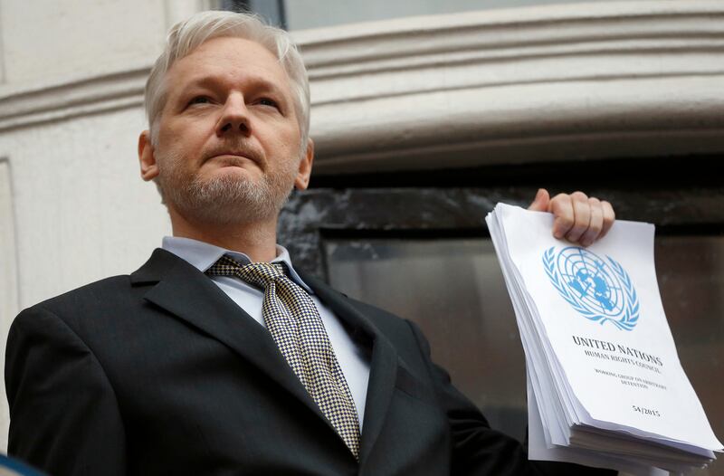 FILE - This is a Friday, Feb. 5, 2016 file photo of WikiLeaks founder Julian Assange holds a U.N. report as he speaks on the balcony of the Ecuadorian Embassy in London. A British judge is scheduled to rule on Tuesday Feb. 6, 2017 on Julian Assange’s bid