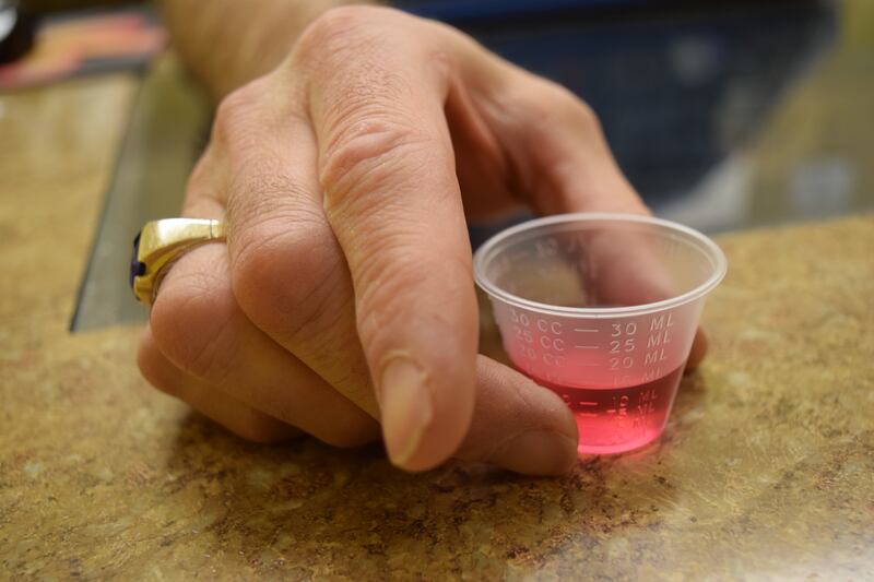 Nurse Steven Horsley holds a dose of liquid methadone, used to treat opioid addiction, at Metamorphosis in Murray on Tuesday, Nov. 28, 2017.
