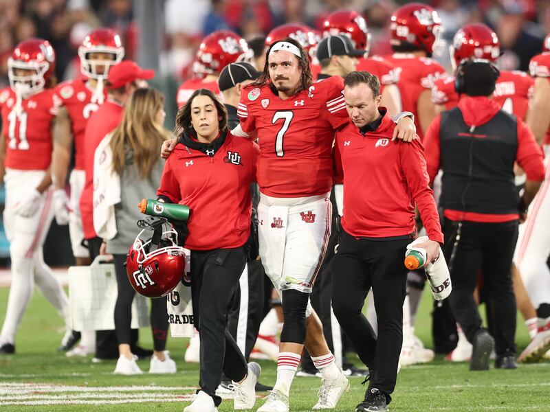 Utah Utes QB Cameron Rising (7) is helped off the field after getting injured on a run as Utah and Penn State play in the Rose Bowl.