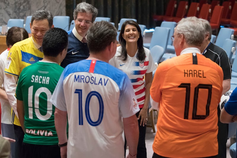 American Ambassador to the United Nations Nikki Haley, center, speaks to other members of the Security Council before posing for a photo wearing the jerseys of their country's soccer teams, Thursday, June 14, 2018, at United Nations headquarters. Russian