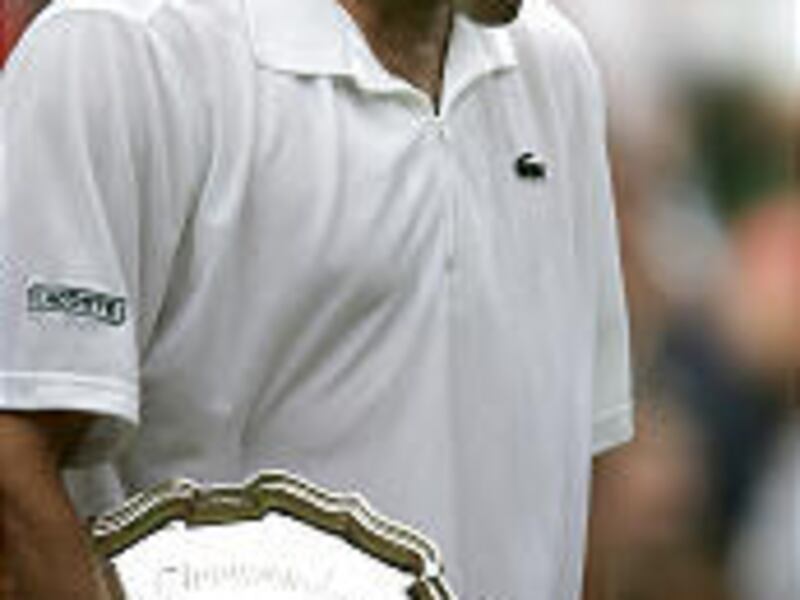 Andy Roddick holds his second-place trophy after being defeated 6-2, 7-6 (2), 6-4 by Roger Federer for the third time in three years.