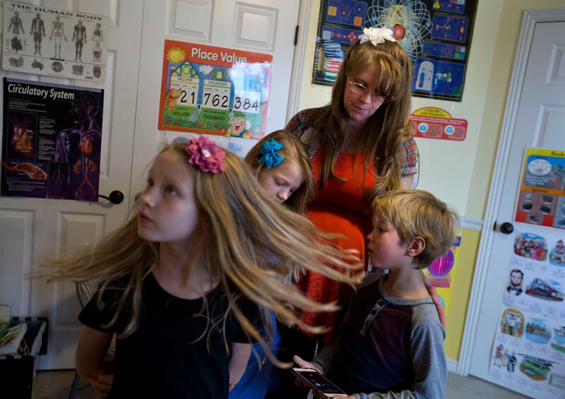 Allison Brown, 8, Haylia Brown, 10, their mother Amy, and Noah Edwards, 8, put the phone on speaker before calling Rep. Mia Love requesting her to support H.R.193 during home-schooling at the Brown home in West Jordan home on Friday, Nov. 3, 2017. This bi
