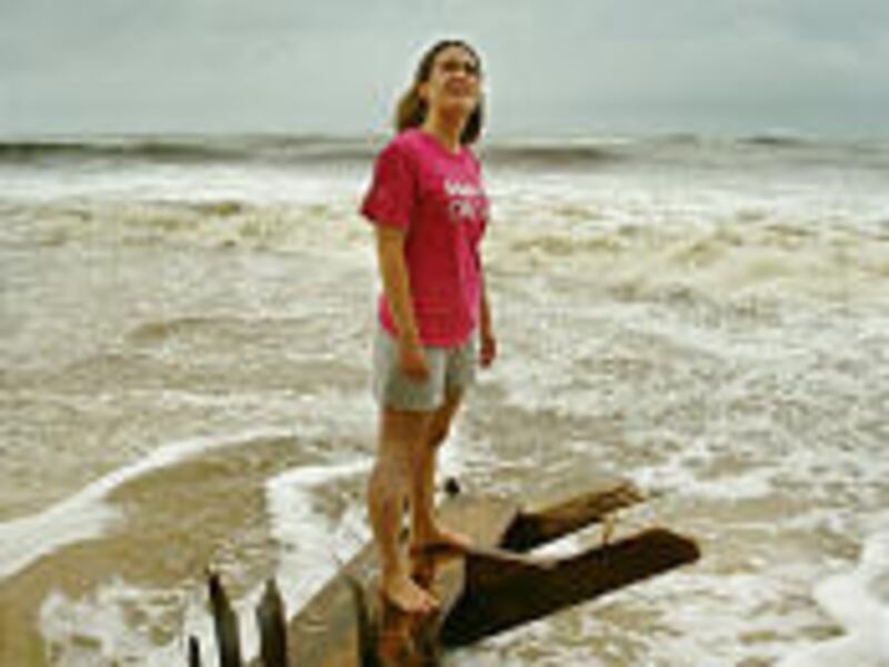 Emily Pash, 20, of Indianapolis, Ind., stands on the remaining steps of her family's rental condo in Gulf Shores, Ala., after Tropical Storm Arlene blew through the area.