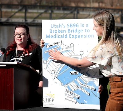 Stacy Stanford, of the Utah Health Policy Project, speaks during a press conference at Liberty Park in Salt Lake City on Monday, April 1, 2019, as Courtney Bullard places tags on a board highlighting areas where Utahns will be left behind through the sta