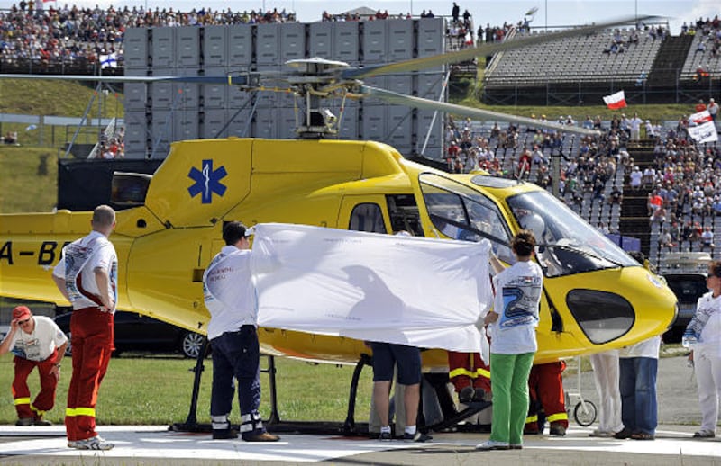 Medical staff holds a blanket to cover Ferrari Formula One driver Felipe Massa of Brazil as he is brought to a helicopter after his accident during the Qualifying session at the Hungaroring circuit near Budapest, Hungary, Saturday.